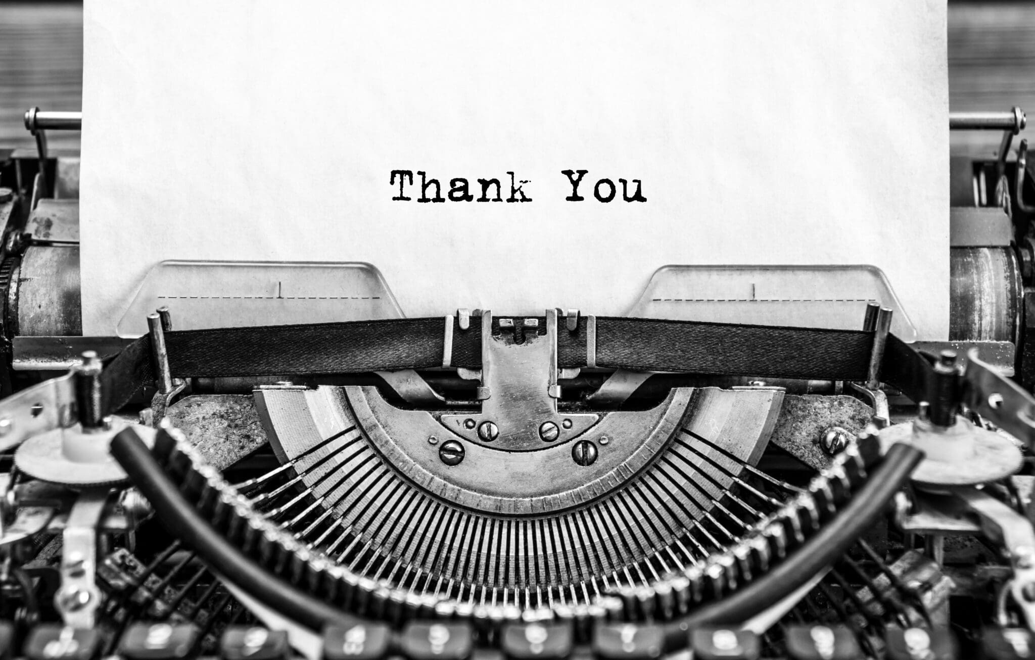 A black and white photo of a typewriter with the word thank you.