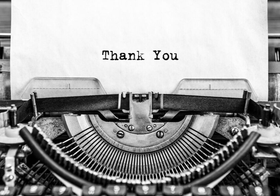 A black and white photo of a typewriter with the word thank you.